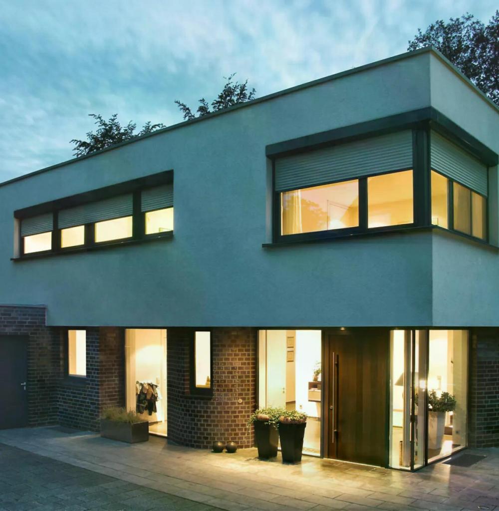 Bild eines Hauses in der Dämmerung mit Rolläden. 
