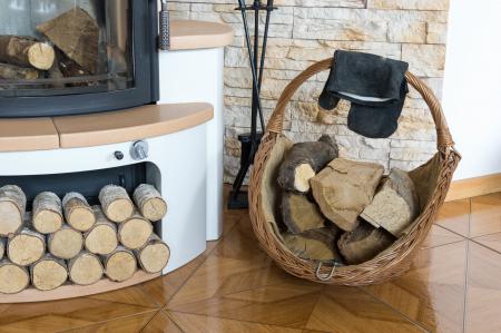 Feuerholz in einem Korb vor dem Kaminofen